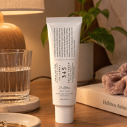 Tubo de Dr. Althea 345 Relief Cream sobre una mesa de noche junto a un vaso de agua